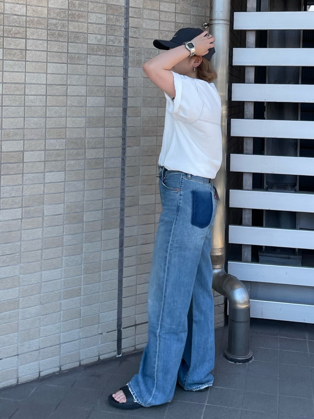 ホワイト系のTシャツ/カットソー、ブルー系のデニムパンツ、グレー系のキャップを着用したレディースの夏コーディネートの2枚目の写真