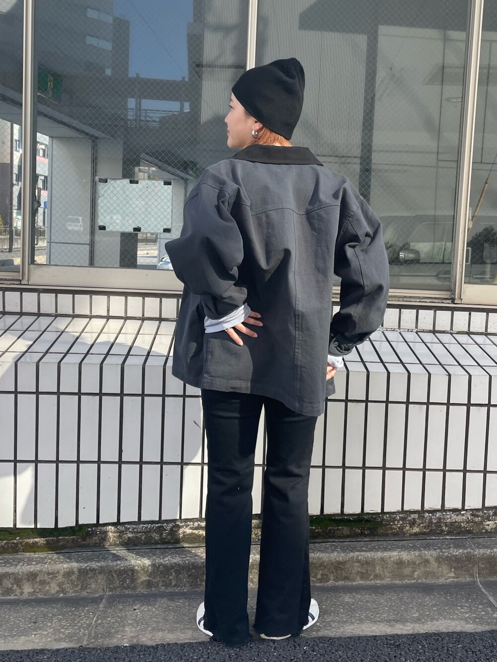 ホワイト系のブルゾン、ブラック系のデニムパンツ、ブルー系のニット/セーターを着用したレディースの春コーディネートの3枚目の写真