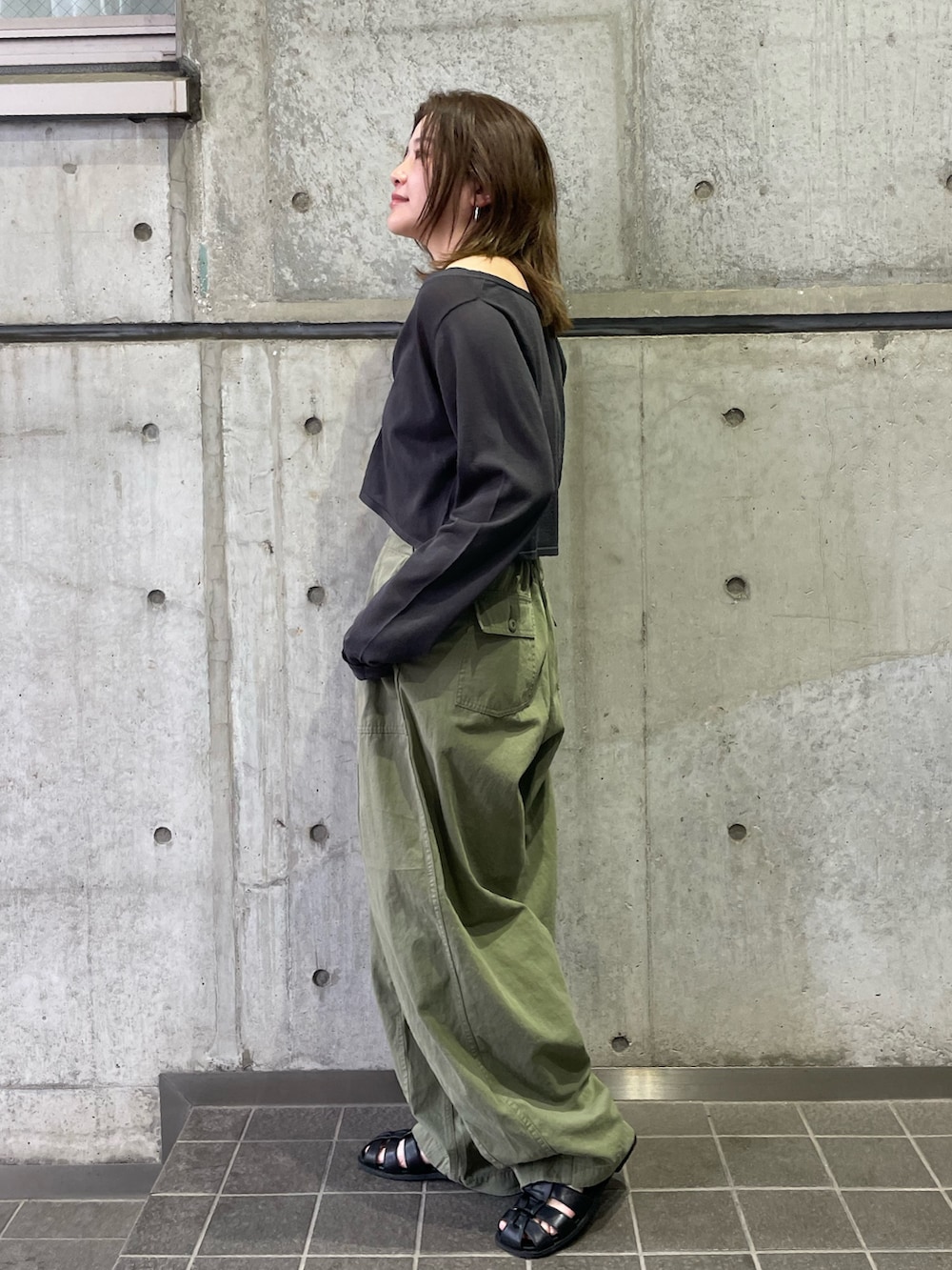 グリーン系のその他パンツ、グレー系のカーディガン/ボレロ、ブラック系のサンダルを着用したレディースの春コーディネートの2枚目の写真