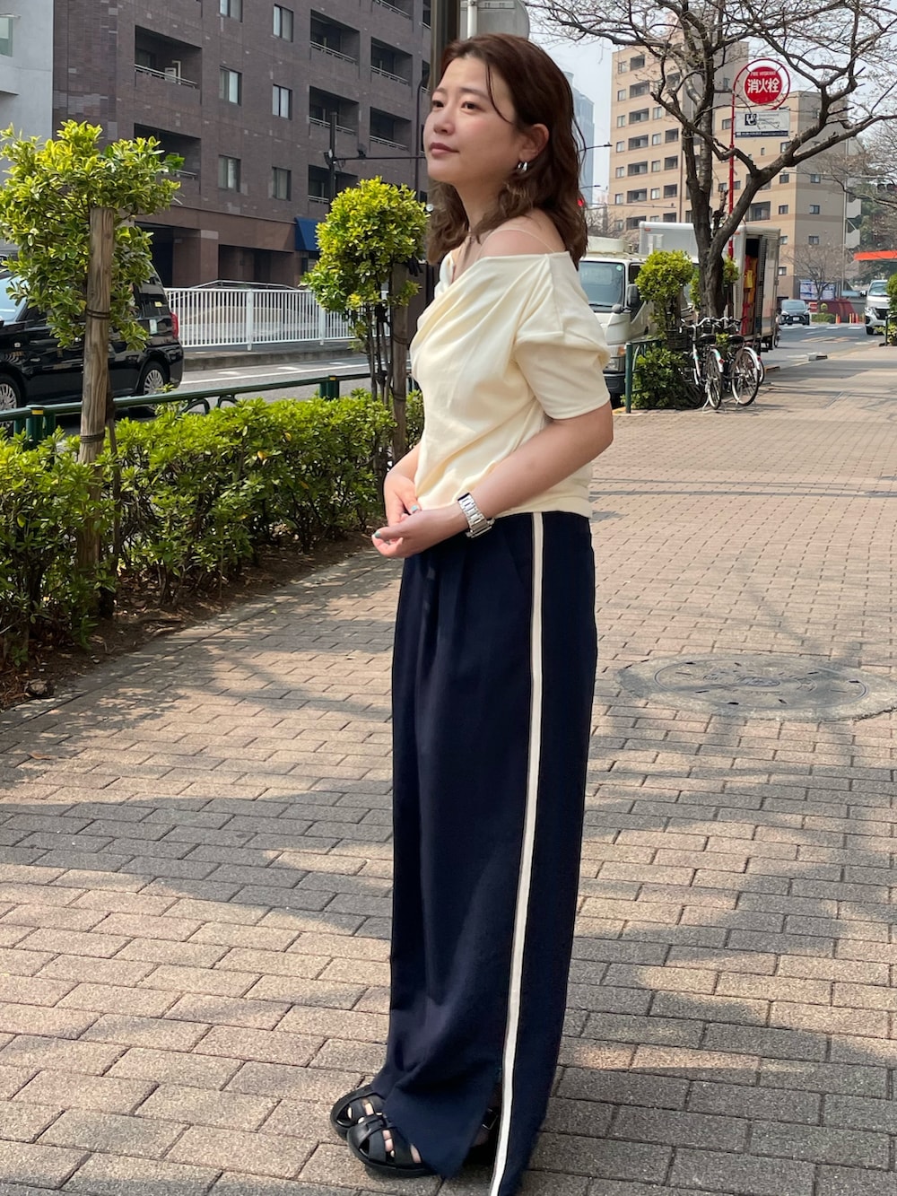 ホワイト系のTシャツ/カットソー、ブルー系のその他パンツ、ブラック系のサンダルを着用したレディースの春コーディネートの3枚目の写真