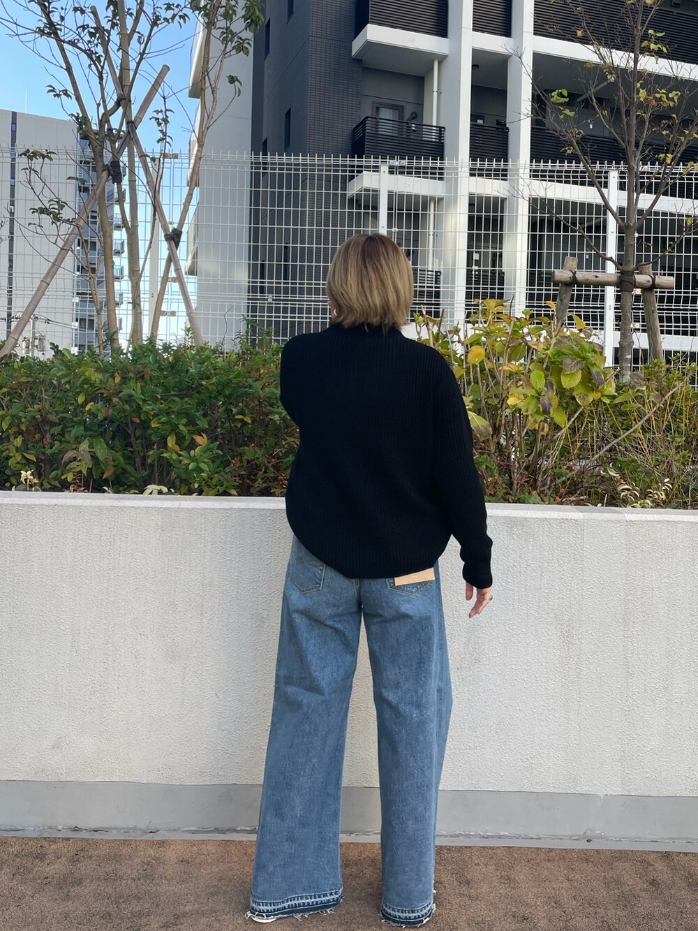 ブラック系のニット/セーター、ブルー系のデニムパンツ、ピンク系のスニーカーを着用したレディースの冬コーディネートの3枚目の写真