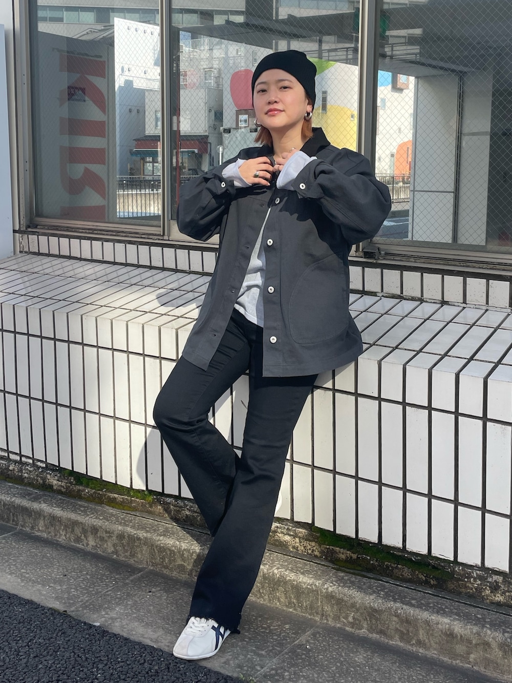 ホワイト系のブルゾン、ブラック系のデニムパンツ、ブルー系のニット/セーターを着用したレディースの春コーディネートの2枚目の写真