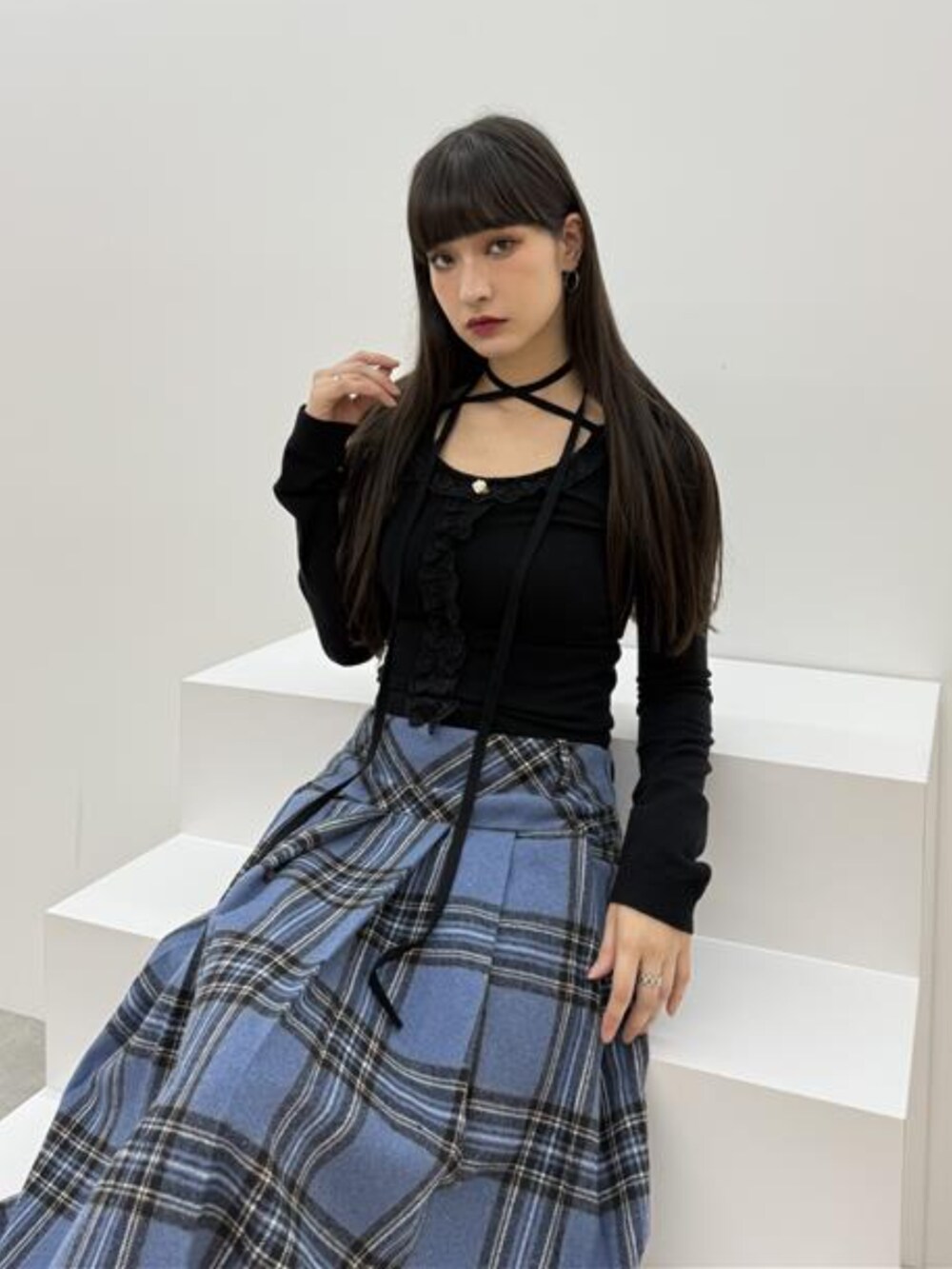 ブラック系のブーツ、ブラック系のニット/セーター、ブルー系のスカートを着用したレディースの秋コーディネートの5枚目の写真