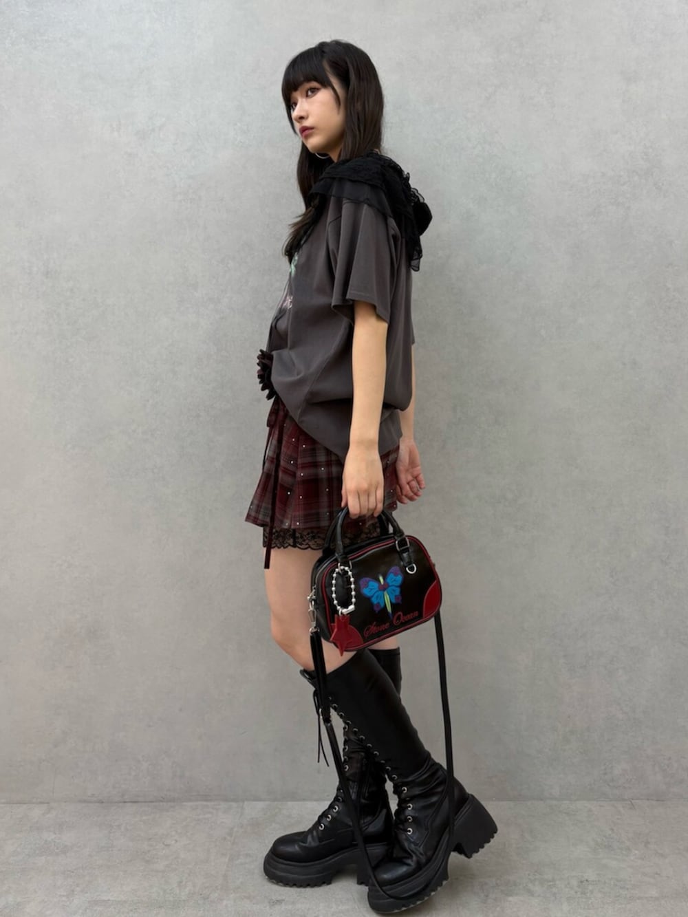 ブラック系のブーツ、レッド系のスカート、ブラック系のTシャツ/カットソーを着用したレディースの冬コーディネートの3枚目の写真