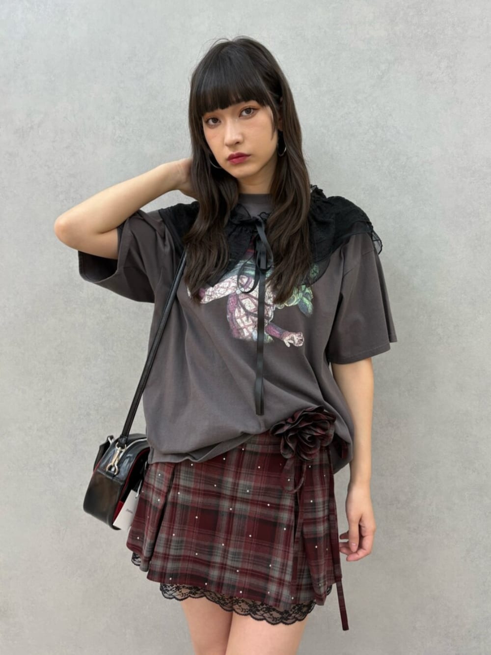 ブラック系のブーツ、レッド系のスカート、ブラック系のTシャツ/カットソーを着用したレディースの冬コーディネートの2枚目の写真