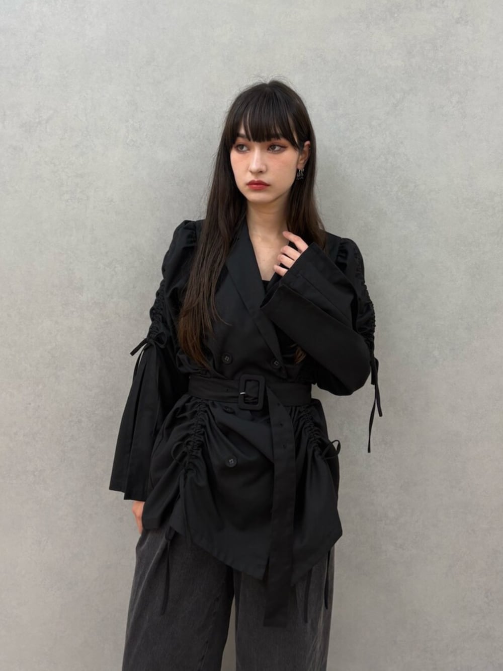 ブラック系のテーラードジャケット、ブラック系のデニムパンツ、ブラック系のパンプスを着用したレディースの夏コーディネートの5枚目の写真