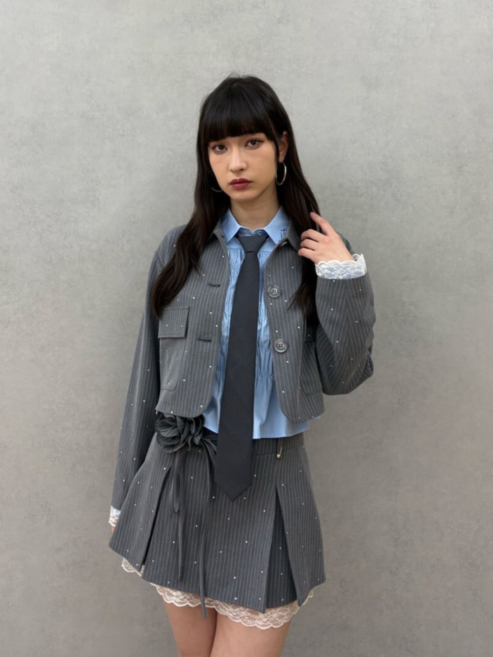 ブラック系のブーツ、グレー系のテーラードジャケット、グレー系のスカートを着用したレディースの冬コーディネートの2枚目の写真