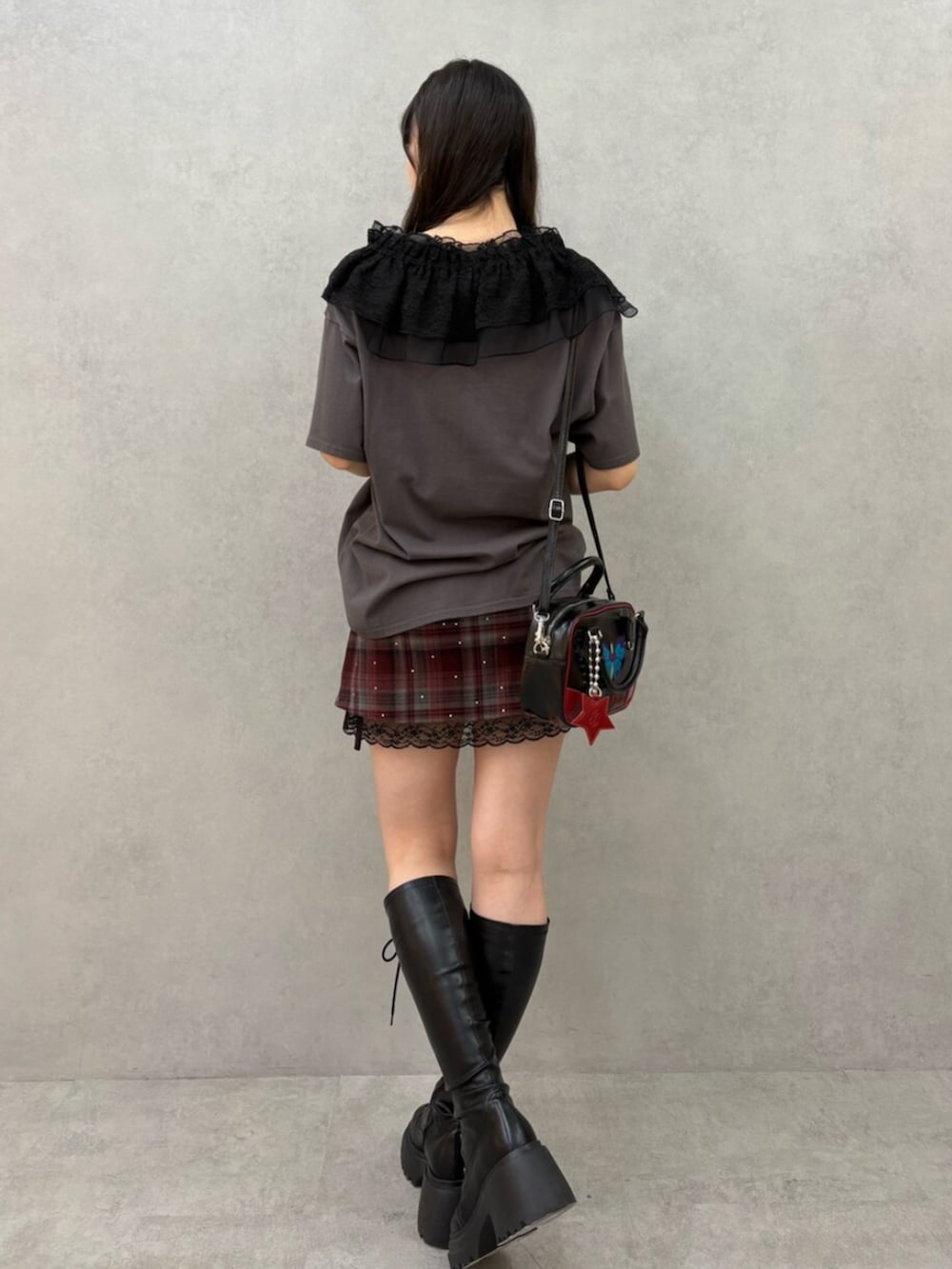 ブラック系のブーツ、レッド系のスカート、ブラック系のTシャツ/カットソーを着用したレディースの冬コーディネートの4枚目の写真