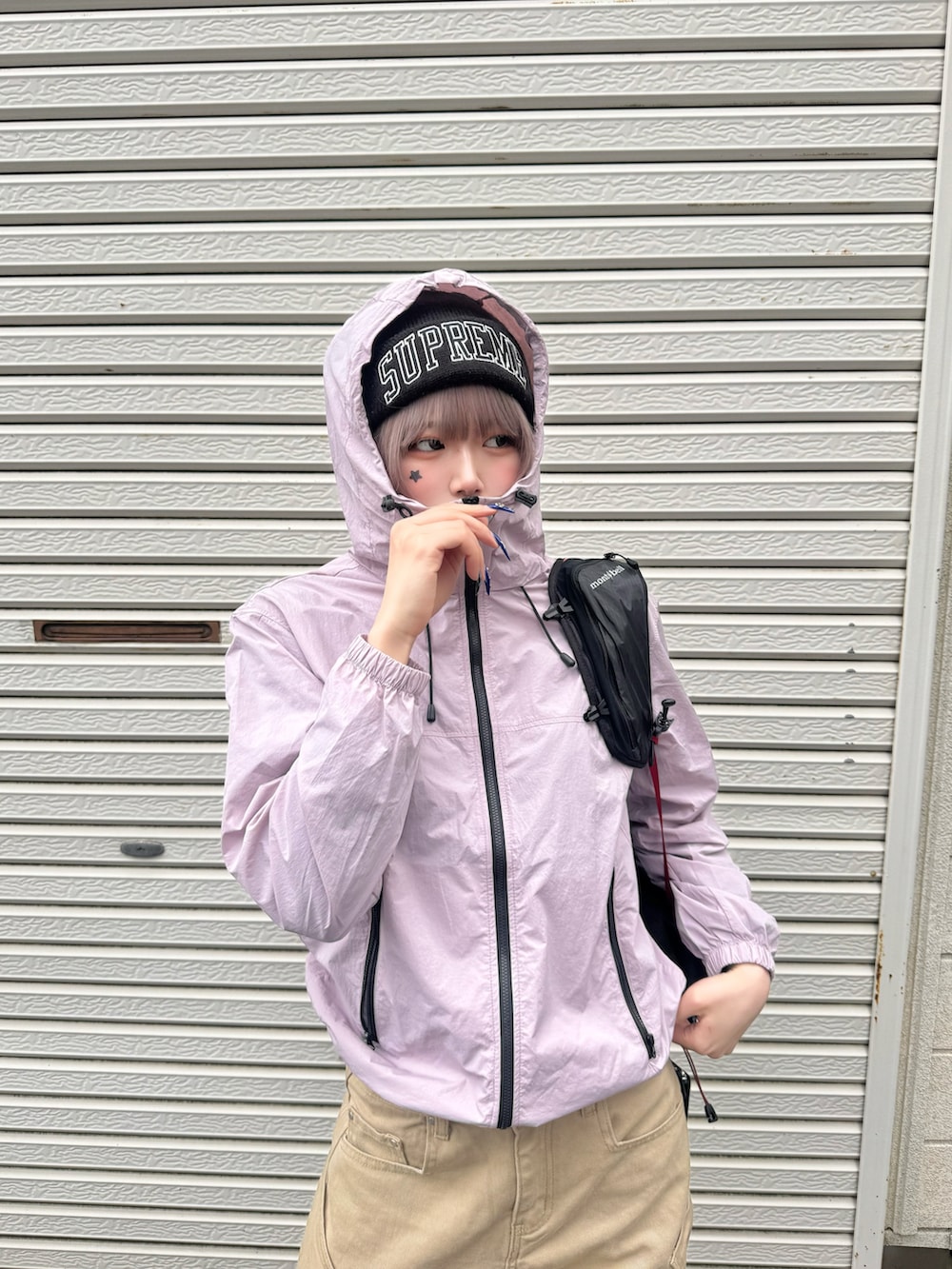 ベージュ系のチノパンツ、ブラウン系のシューズ、ピンク系のナイロンジャケットを着用したレディースの春コーディネートの3枚目の写真