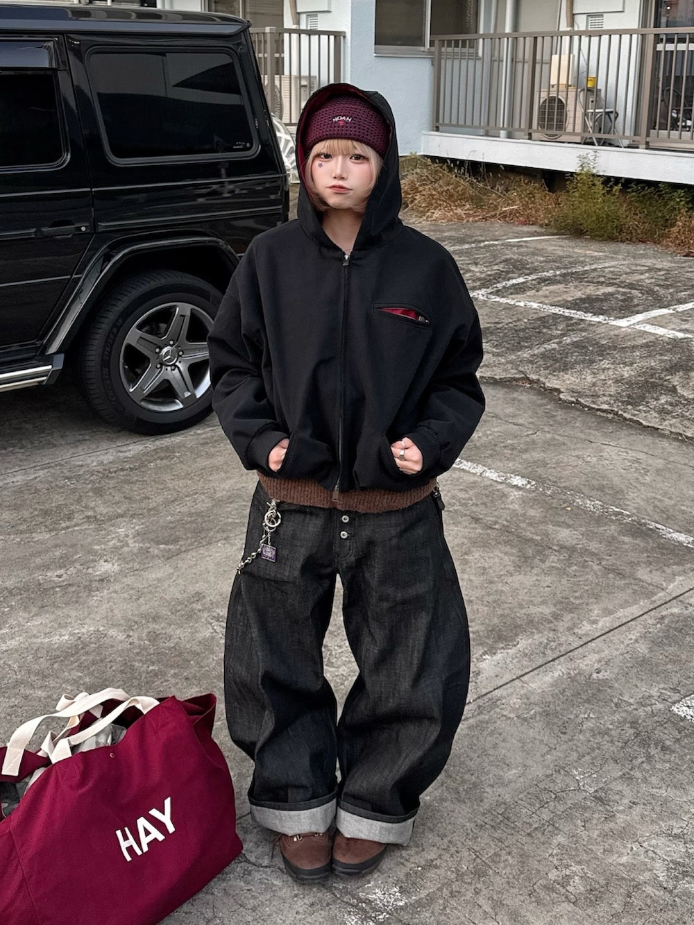 ブラック系のデニムパンツ、ブラウン系のブーツ、ブラック系のジャケット/アウターを着用したレディースの冬コーディネートの2枚目の写真