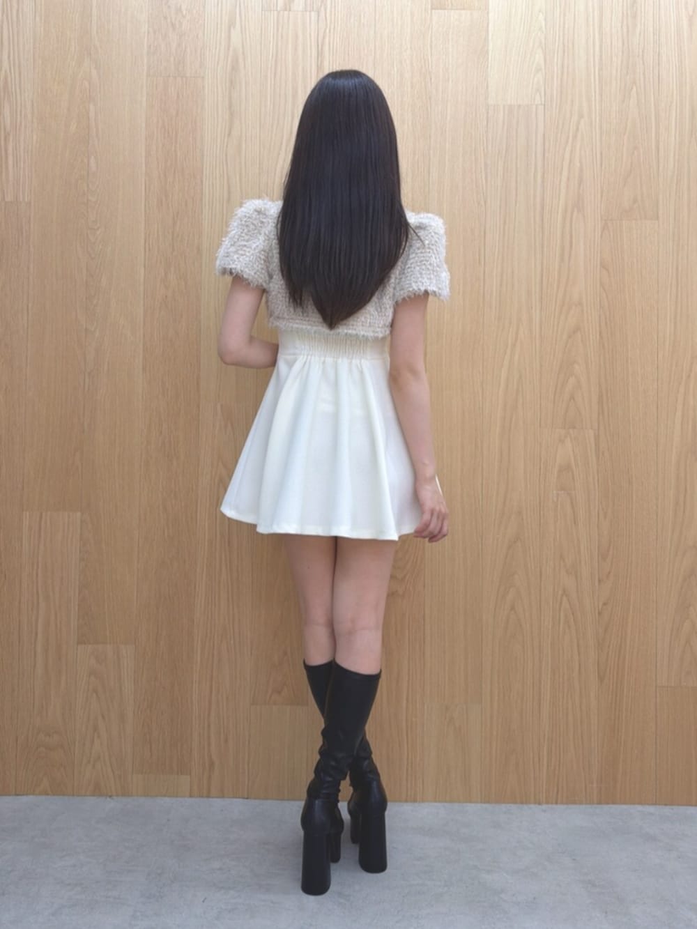 ホワイト系のワンピース、ブラック系のブーツを着用したレディースの夏コーディネートの3枚目の写真