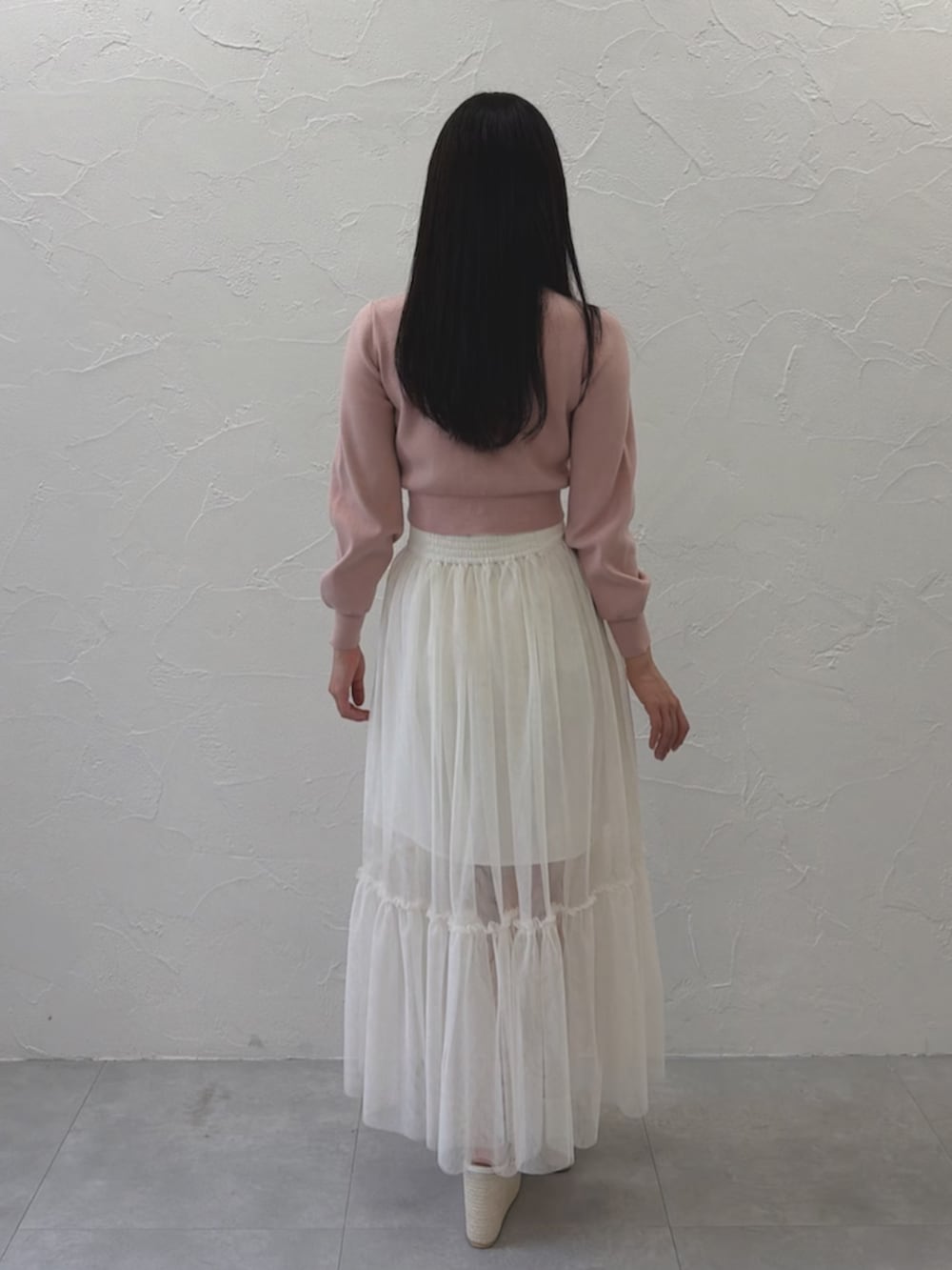 ホワイト系のスカート、ピンク系のカーディガン/ボレロ、ホワイト系のサンダルを着用したレディースの春コーディネートの3枚目の写真