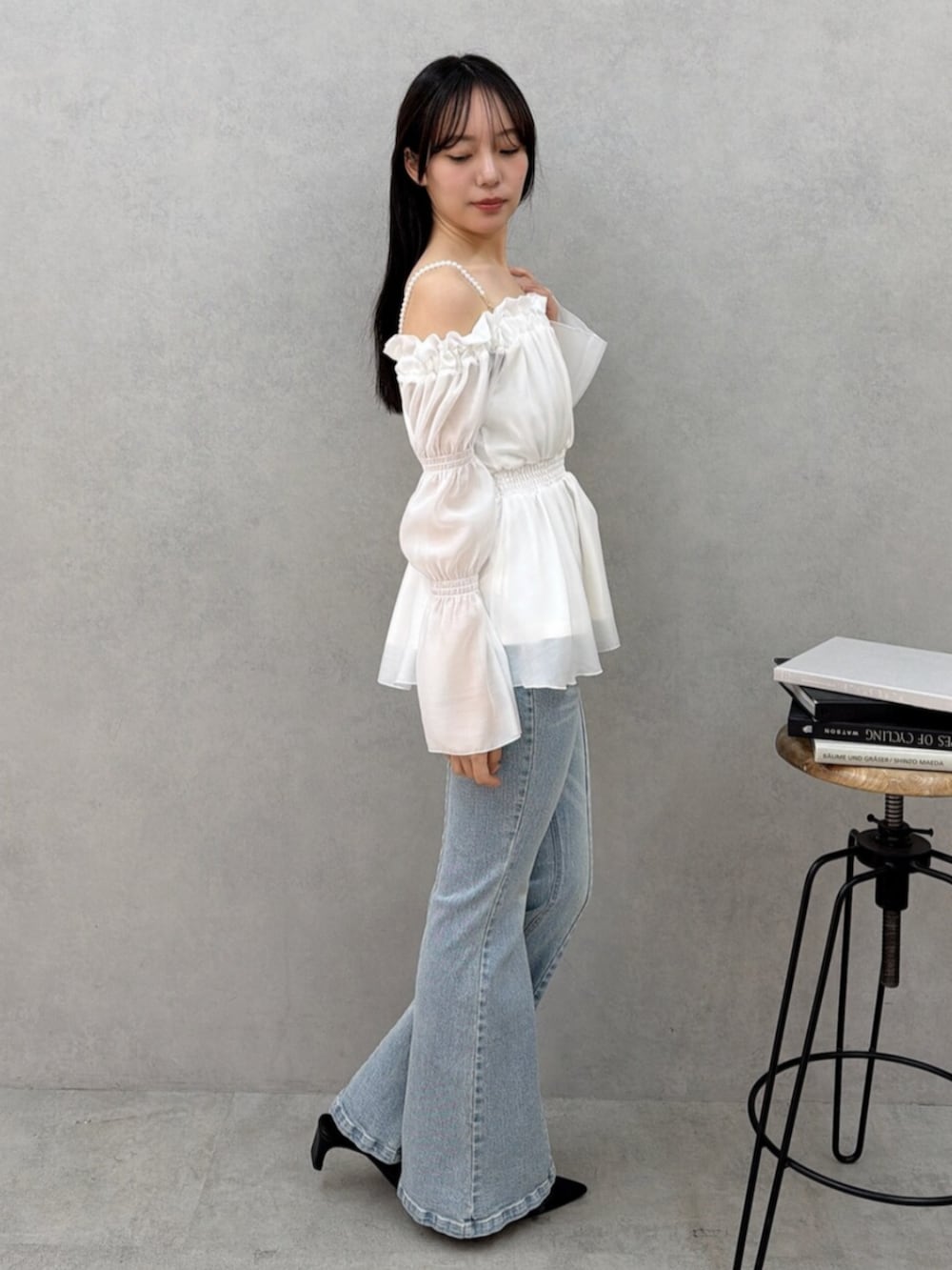 ホワイト系のシャツ/ブラウス、ブラック系のパンプス、ブルー系のデニムパンツを着用したレディースの冬コーディネートの2枚目の写真