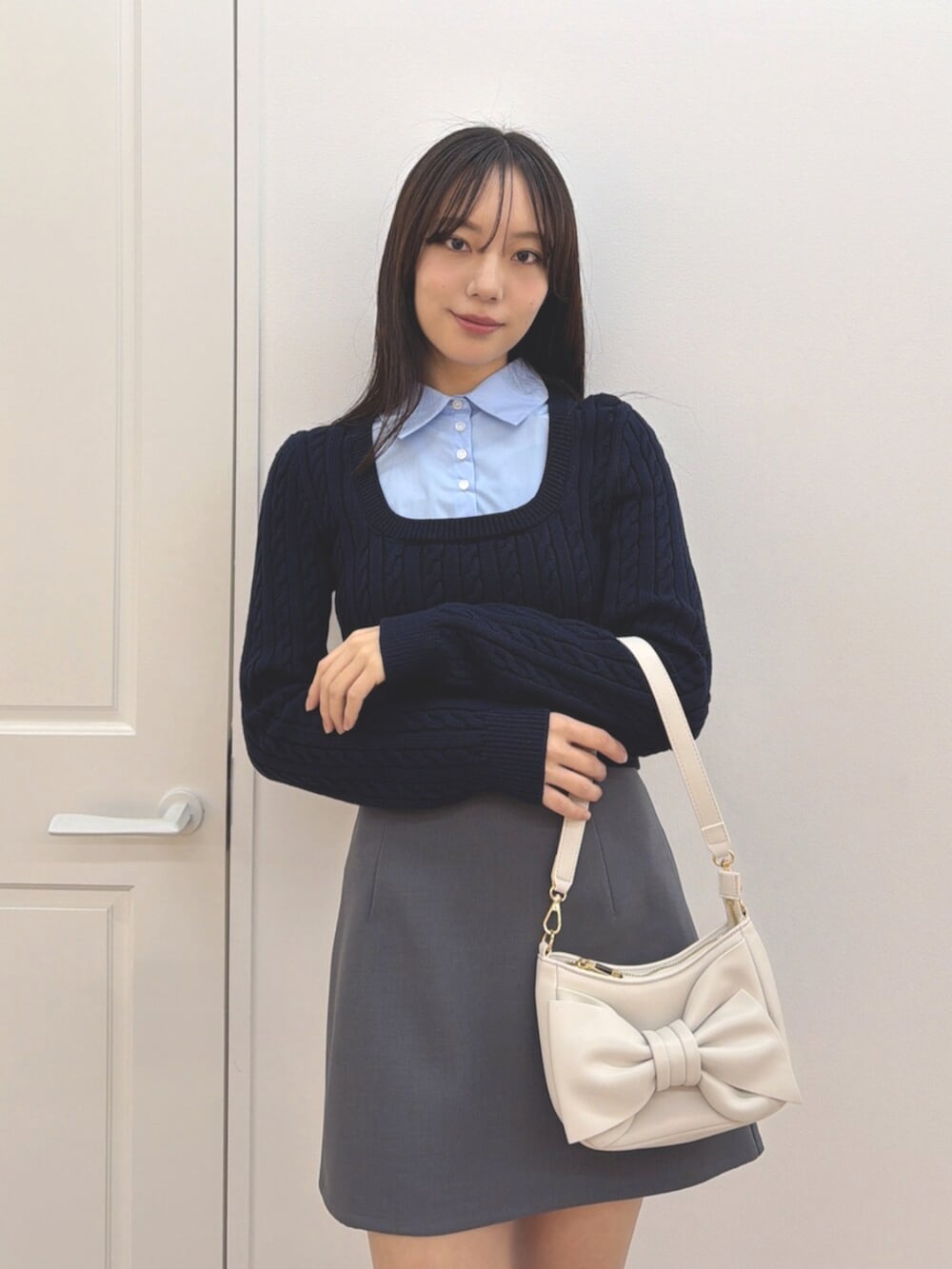 ブルー系のニット/セーター、グレー系のスカート、ブラック系のブーツを着用したレディースの冬コーディネートの4枚目の写真