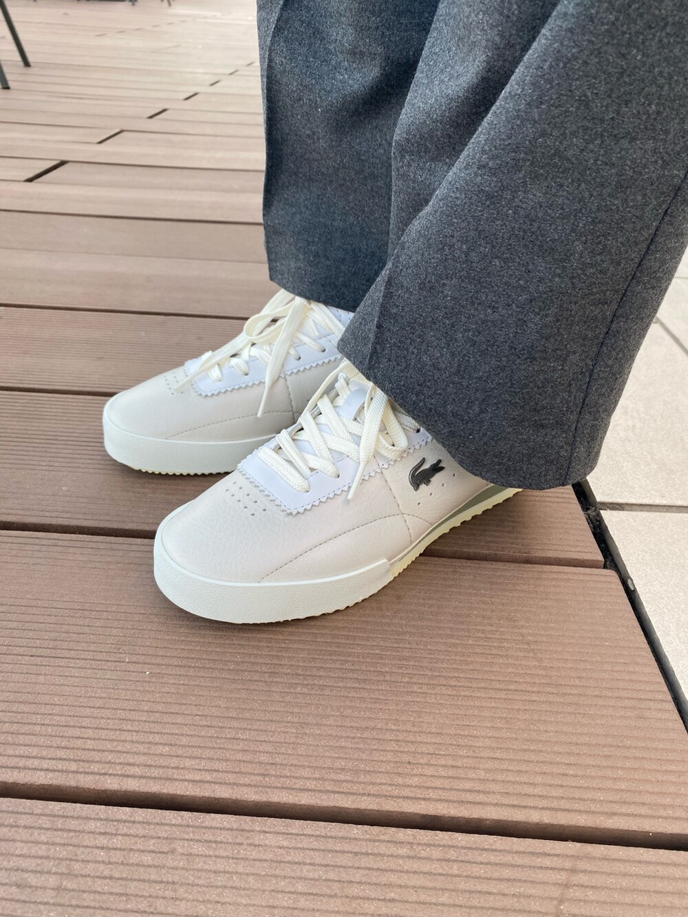 グリーン系のニット/セーター、グレー系のその他パンツ、ホワイト系のスニーカーを着用したレディースの冬コーディネートの6枚目の写真