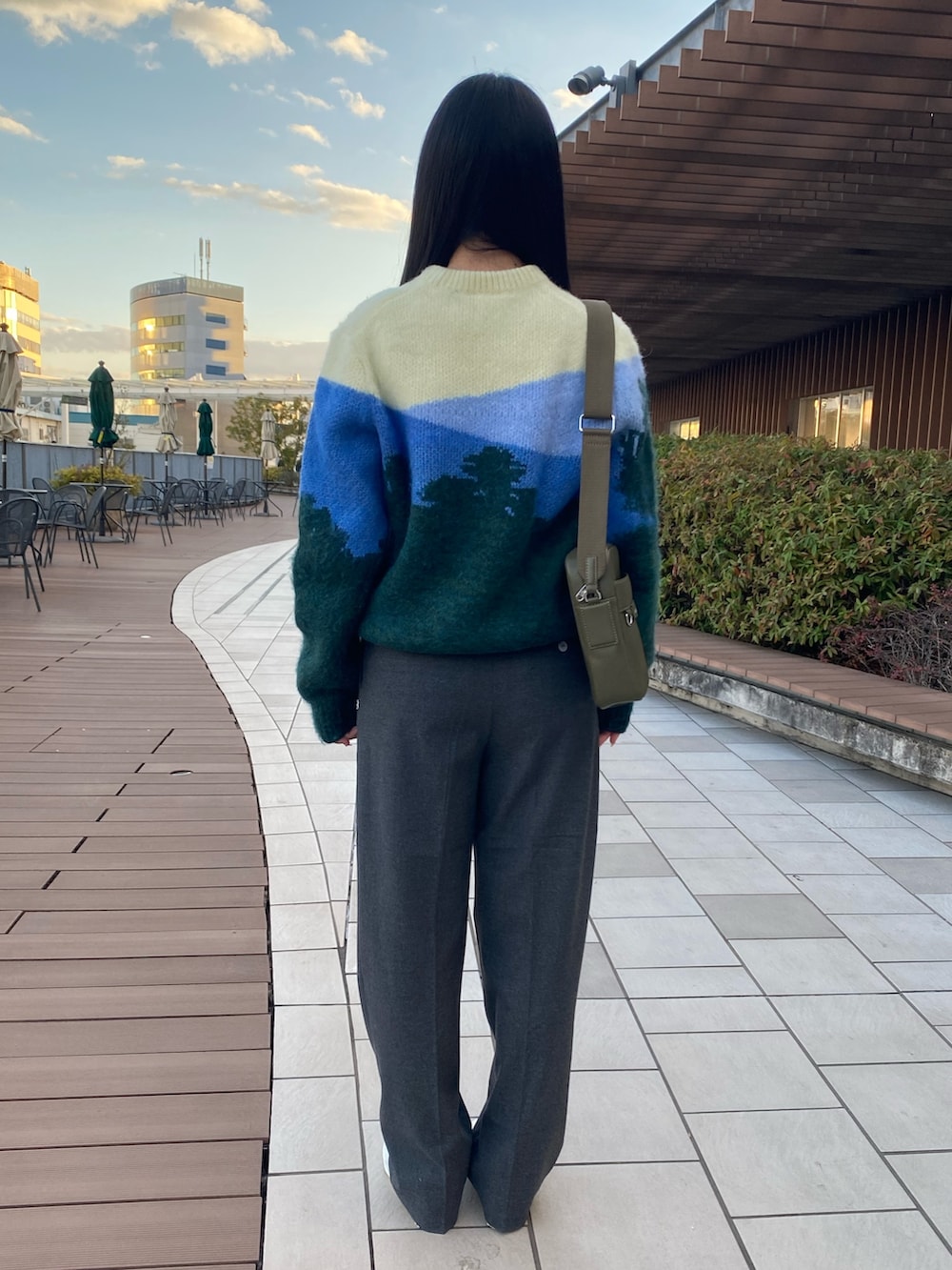 グリーン系のニット/セーター、グレー系のその他パンツ、ホワイト系のスニーカーを着用したレディースの冬コーディネートの3枚目の写真