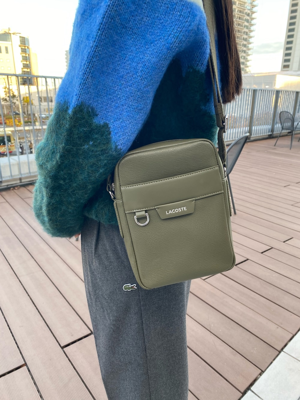 グリーン系のニット/セーター、グレー系のその他パンツ、ホワイト系のスニーカーを着用したレディースの冬コーディネートの5枚目の写真