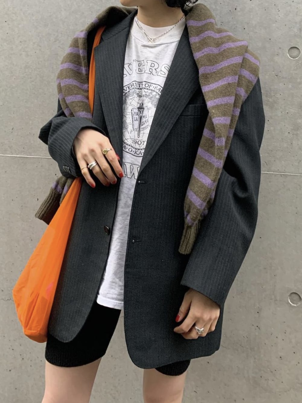 ホワイト系のスニーカー、グリーン系のニット/セーター、オレンジ系のトートバッグを着用したレディースの春コーディネートの2枚目の写真