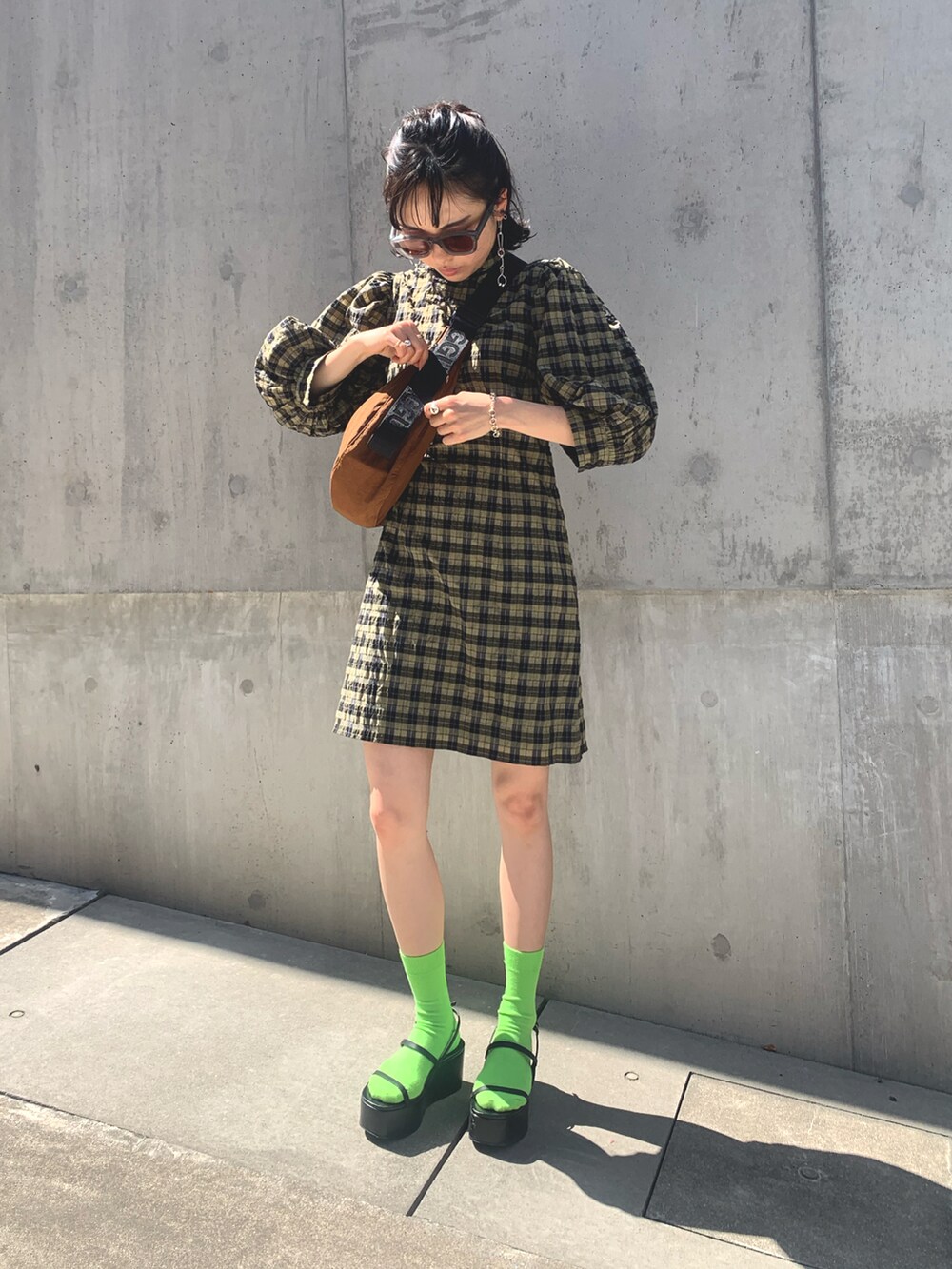 グリーン系のワンピース、ブラウン系のショルダーバッグ、グリーン系のソックス/靴下を着用したレディースの春コーディネートの2枚目の写真