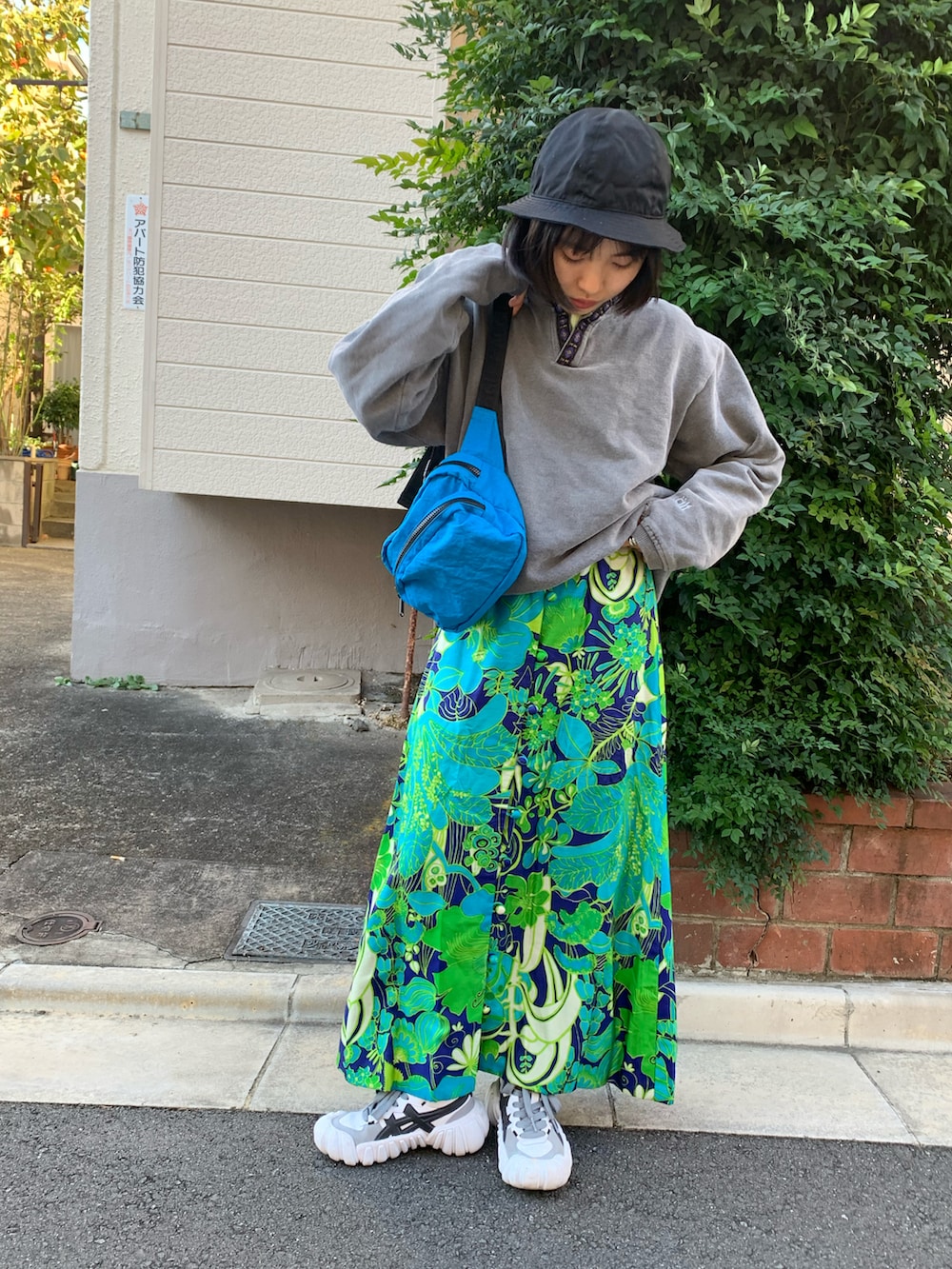 ホワイト系のスニーカー、ブルー系のスカート、グレー系のスウェットを着用したレディースの秋コーディネートの3枚目の写真