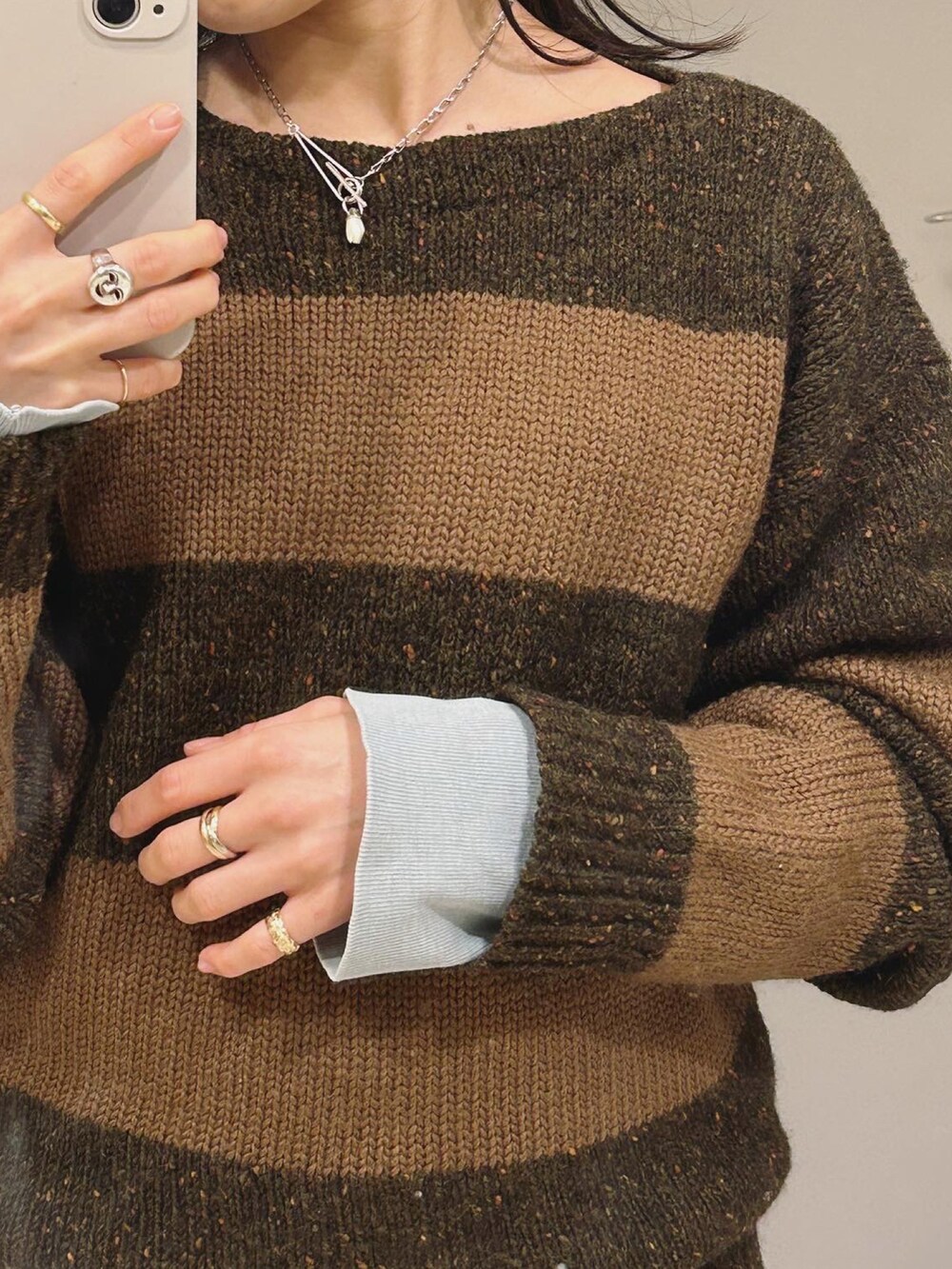 ブラウン系のニット/セーター、ホワイト系のパンツを着用したレディースの春コーディネートの2枚目の写真