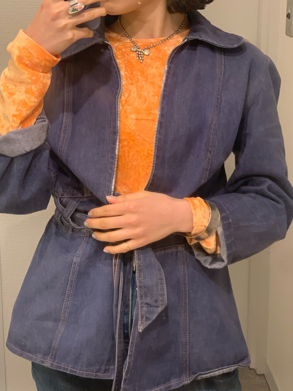 オレンジ系のTシャツ/カットソー、ベージュ系のショルダーバッグ、ブルー系のデニムパンツを着用したレディースの春コーディネートの5枚目の写真