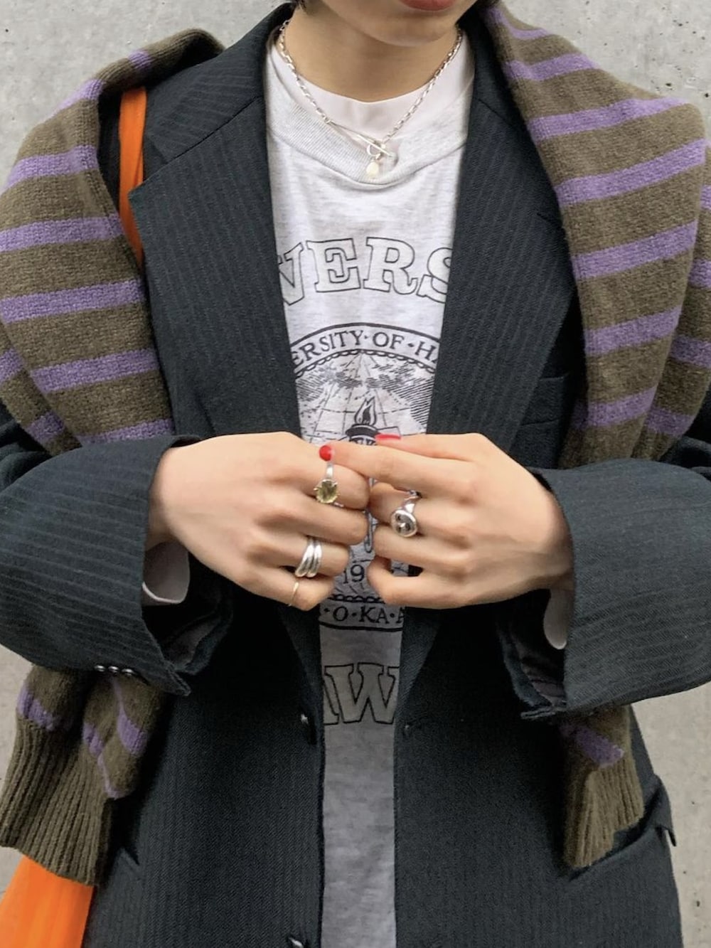 ホワイト系のスニーカー、グリーン系のニット/セーター、オレンジ系のトートバッグを着用したレディースの春コーディネートの3枚目の写真