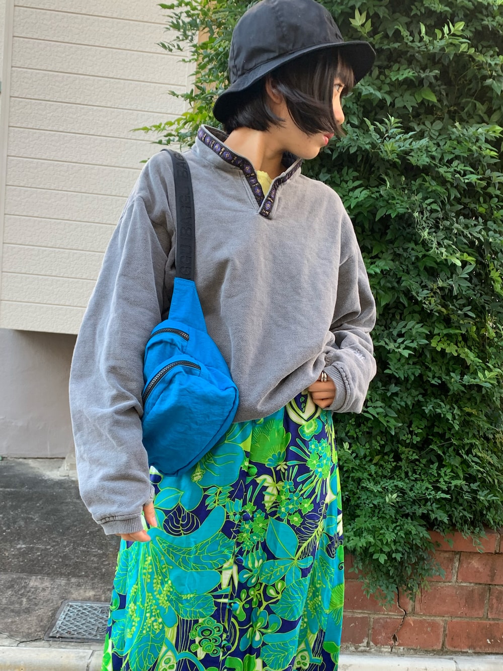 ホワイト系のスニーカー、ブルー系のスカート、グレー系のスウェットを着用したレディースの秋コーディネートの2枚目の写真