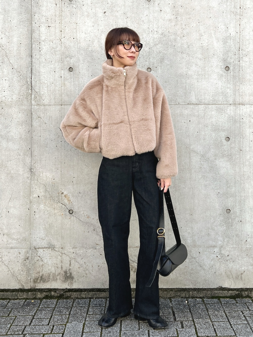 ベージュ系のブルゾン、ブラック系のデニムパンツ、ブラック系のブーツを着用したレディースの秋コーディネートの2枚目の写真