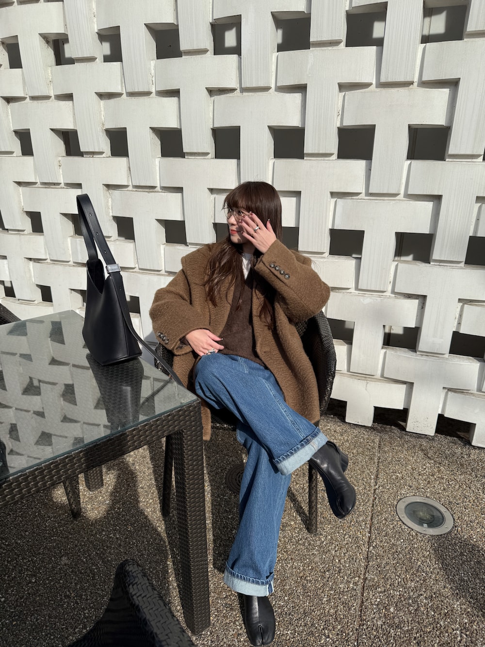 ブラウン系のその他アウター、ブルー系のデニムパンツ、ブラウン系のニット/セーターを着用したレディースの冬コーディネートの4枚目の写真