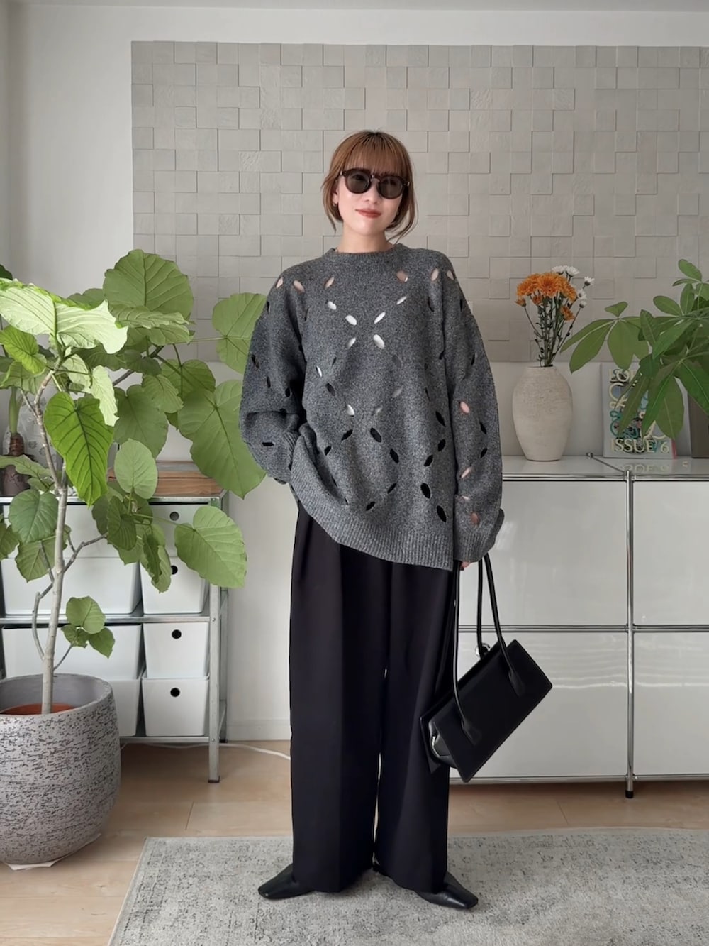 グレー系のニット/セーター、ブラック系のその他パンツ、ブラック系のサンダルを着用したレディースの秋コーディネートの3枚目の写真