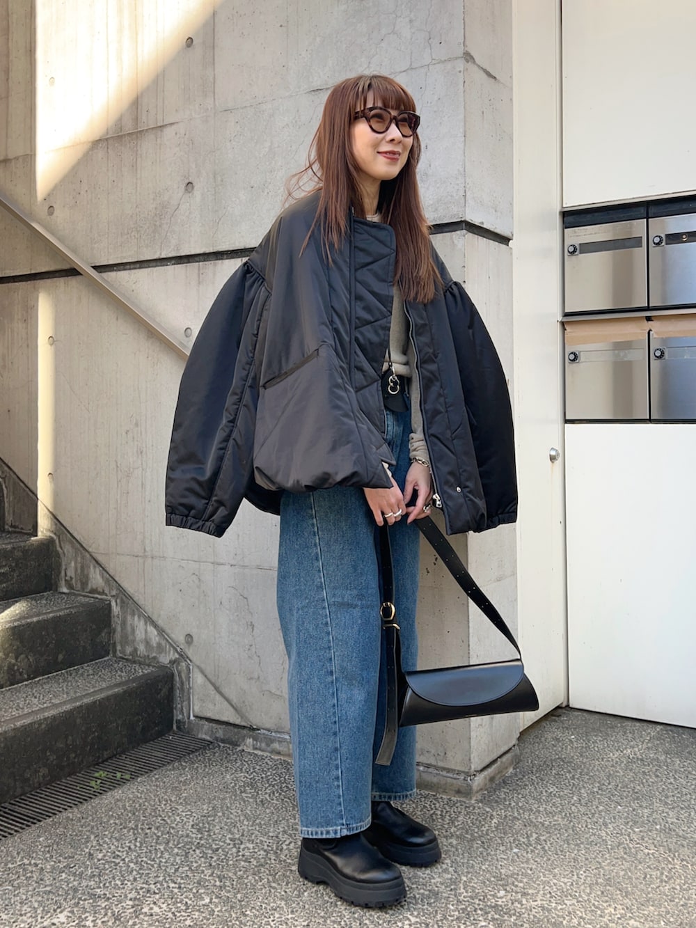 ブラック系のMA-1、ホワイト系のニット/セーター、ブラック系のブーツを着用したレディースの冬コーディネートの3枚目の写真