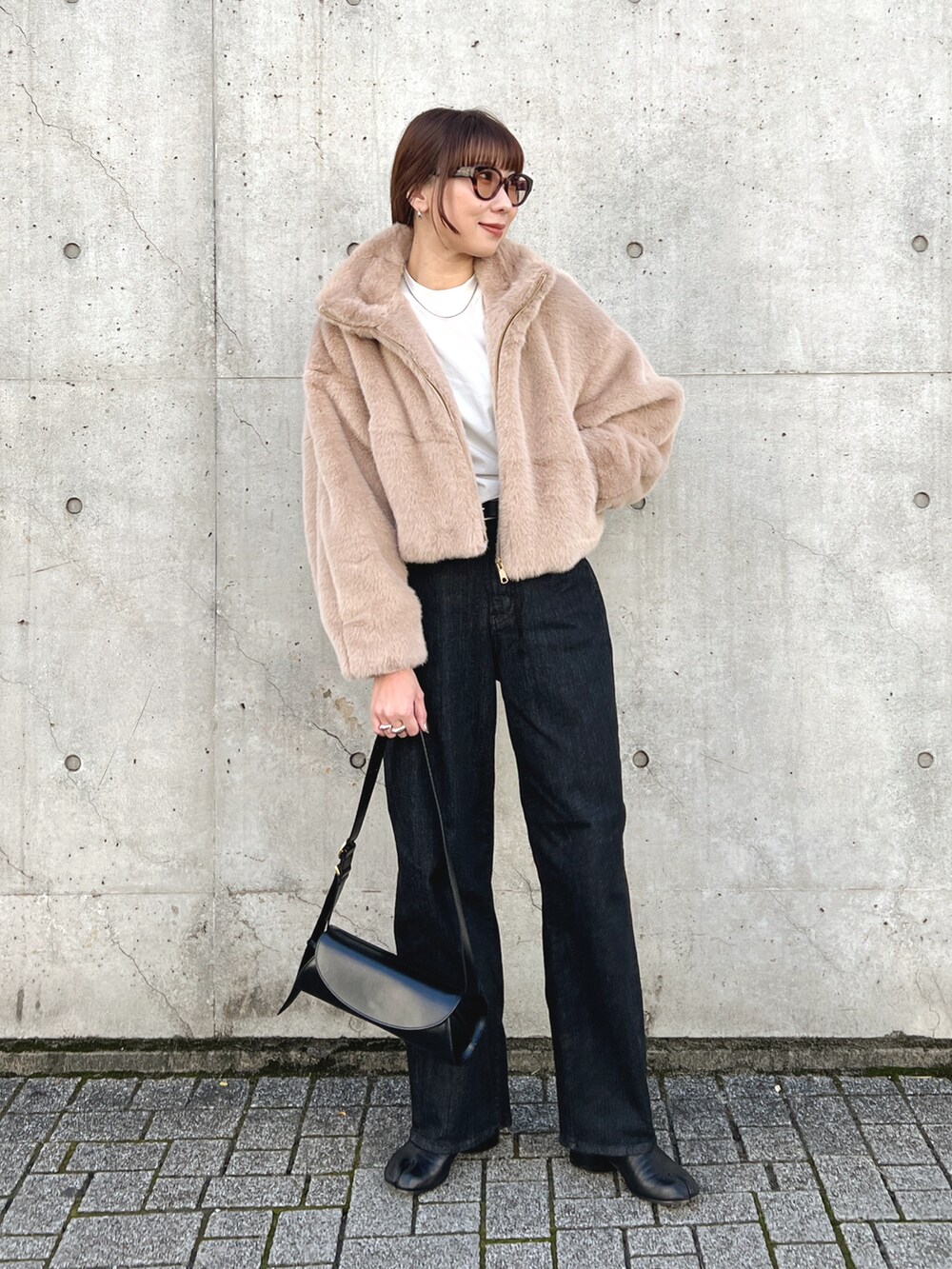 ベージュ系のブルゾン、ブラック系のデニムパンツ、ブラック系のブーツを着用したレディースの秋コーディネートの4枚目の写真