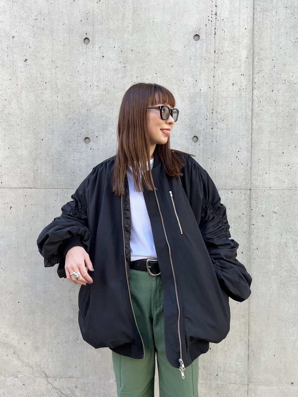 ブラック系のMA-1、ブラック系のハンドバッグ、ホワイト系のTシャツ/カットソーを着用したレディースの冬コーディネートの4枚目の写真