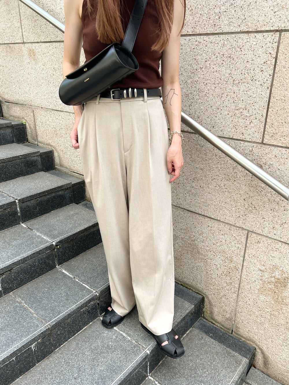 ブラウン系のタンクトップ、ベージュ系のパンツ、ブラック系のショルダーバッグを着用したレディースの夏コーディネートの5枚目の写真
