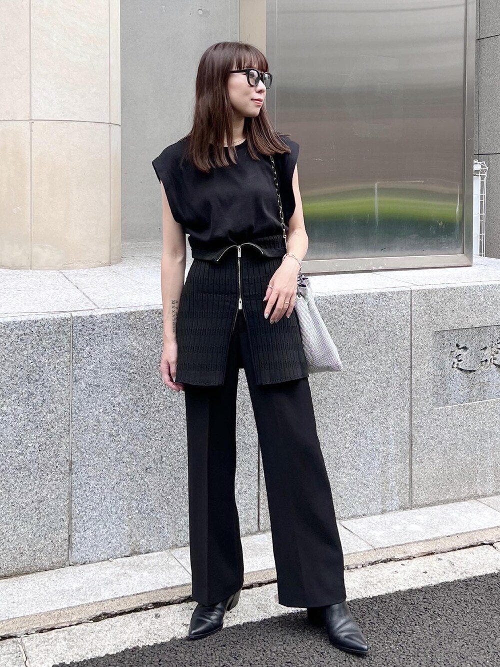 ブラック系のTシャツ/カットソー、ブラック系のスラックス、ブラック系のブーツを着用したレディースの秋コーディネートの2枚目の写真