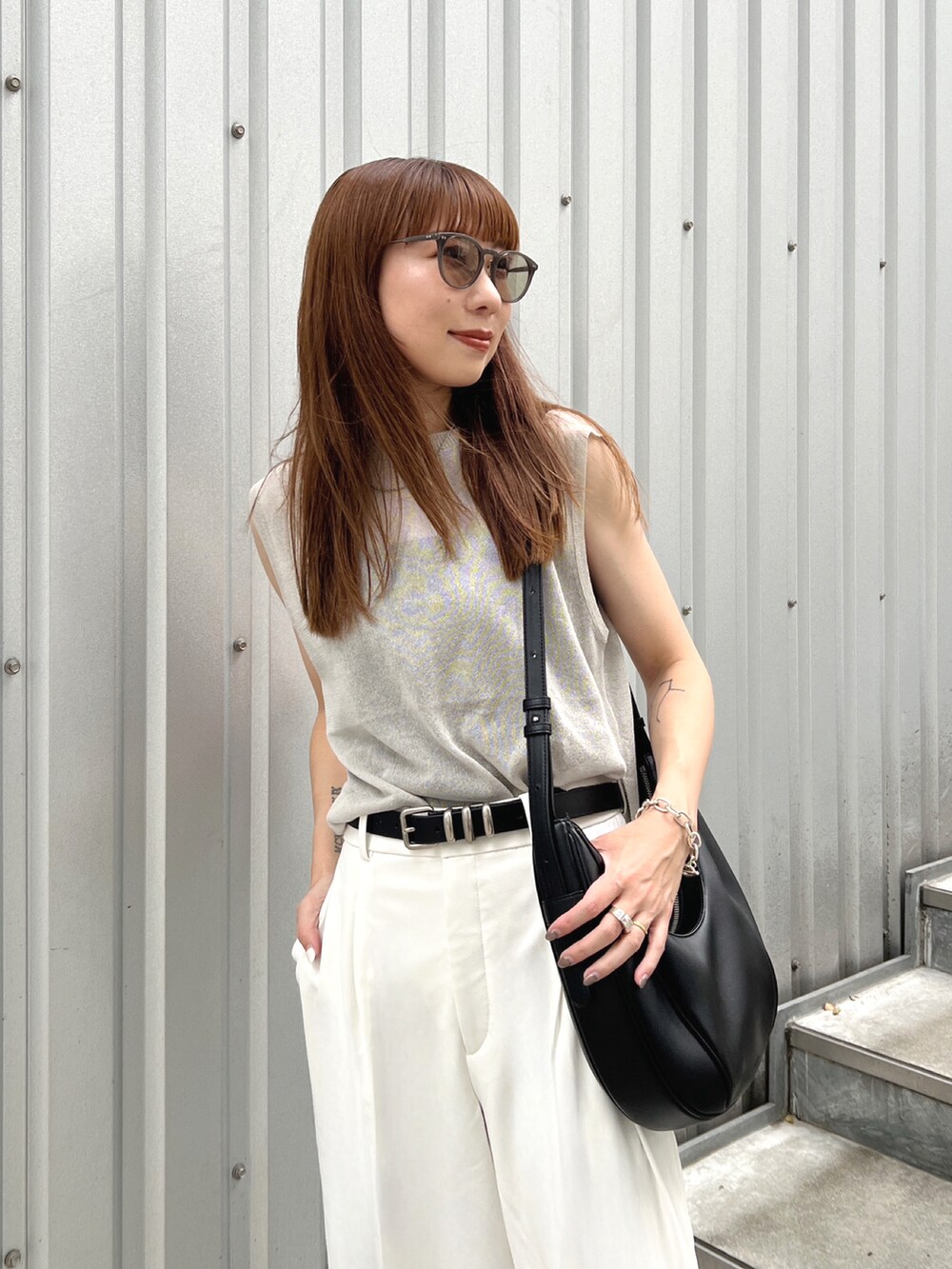 グレー系のTシャツ/カットソー、ブラック系のサンダル、ホワイト系のパンツを着用したレディースの夏コーディネートの5枚目の写真