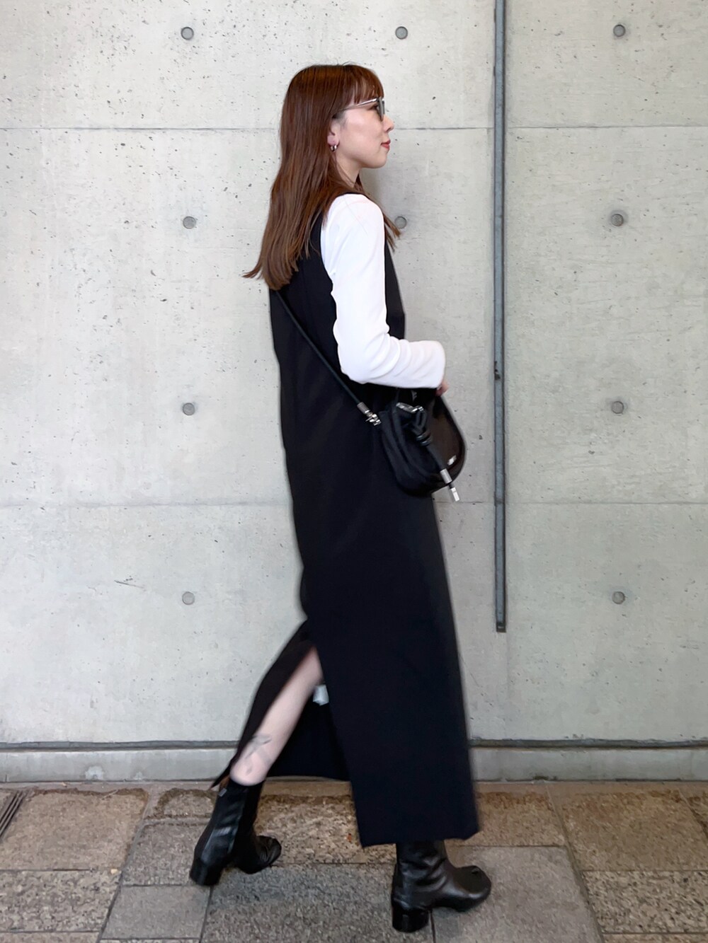 ブラック系のワンピース、ホワイト系のTシャツ/カットソー、ブラック系のハンドバッグを着用したレディースの冬コーディネートの3枚目の写真