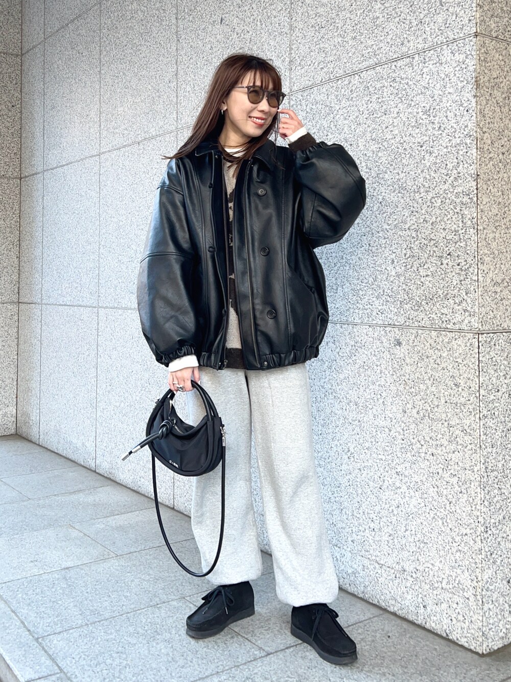 ブラック系のその他アウター、ベージュ系のニット/セーター、ホワイト系のTシャツ/カットソーを着用したレディースの冬コーディネートの2枚目の写真