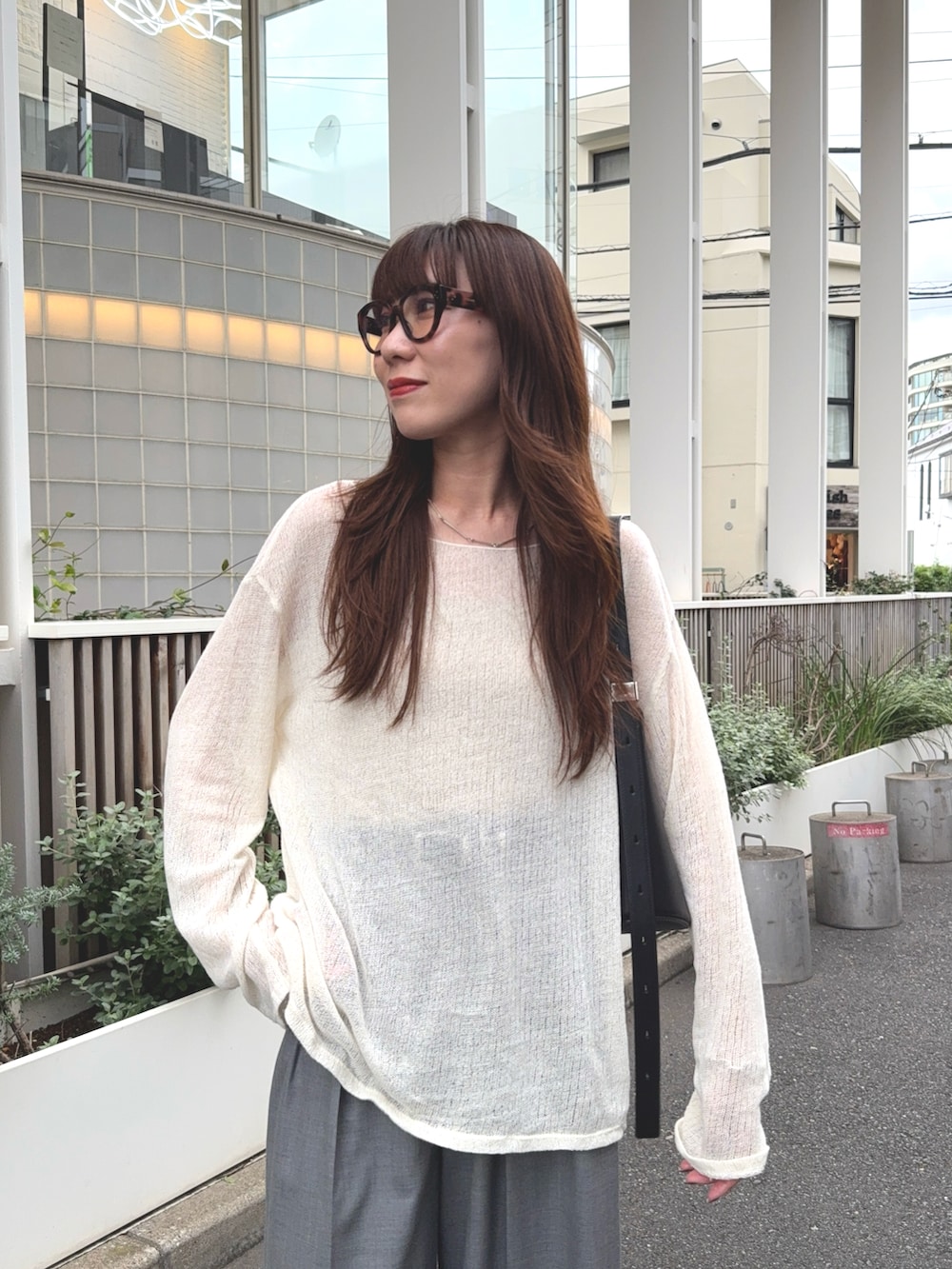 グレー系のその他パンツ、ホワイト系のトップス、ブラック系のバッグを着用したレディースの秋コーディネートの3枚目の写真