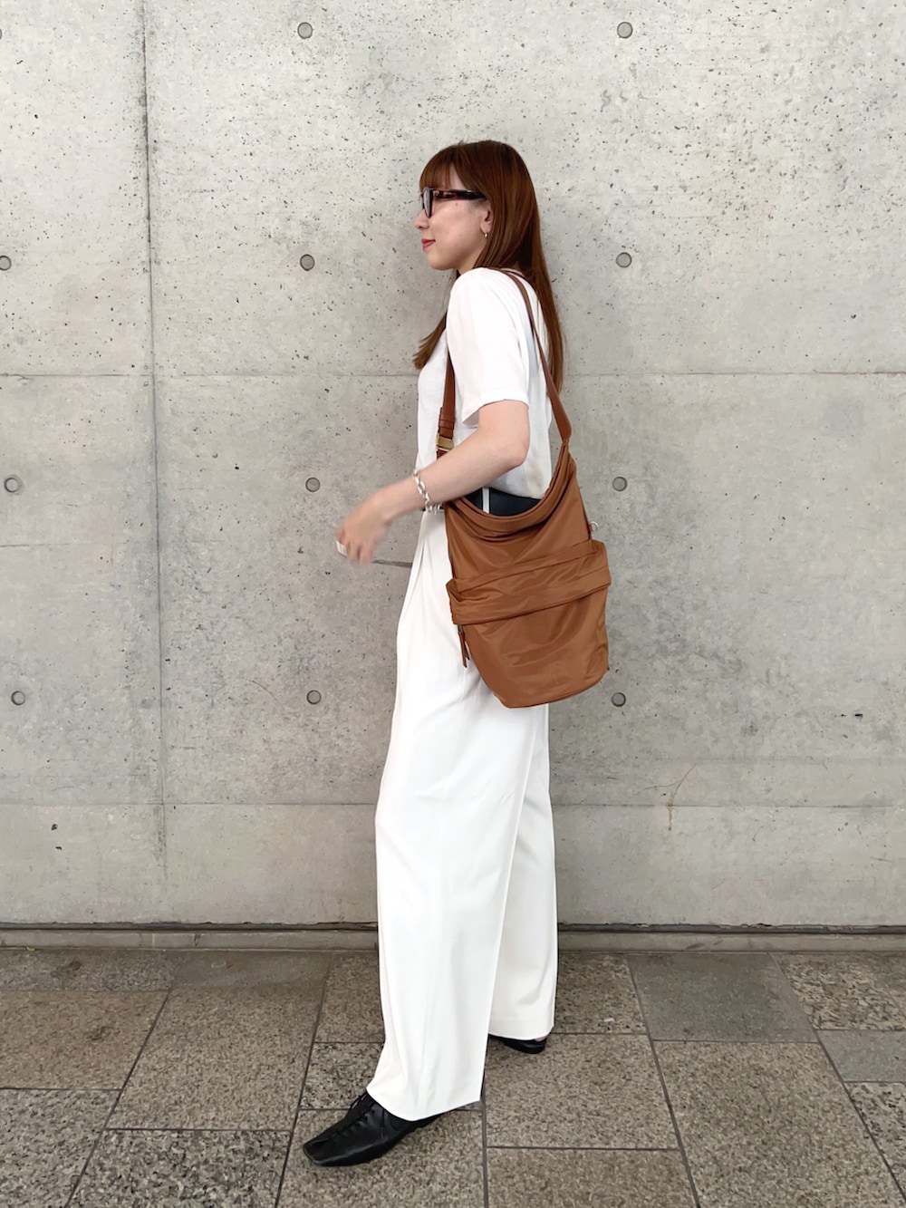 ホワイト系のTシャツ/カットソー、ブラック系のスリッポン、ホワイト系のパンツを着用したレディースの春コーディネートの4枚目の写真