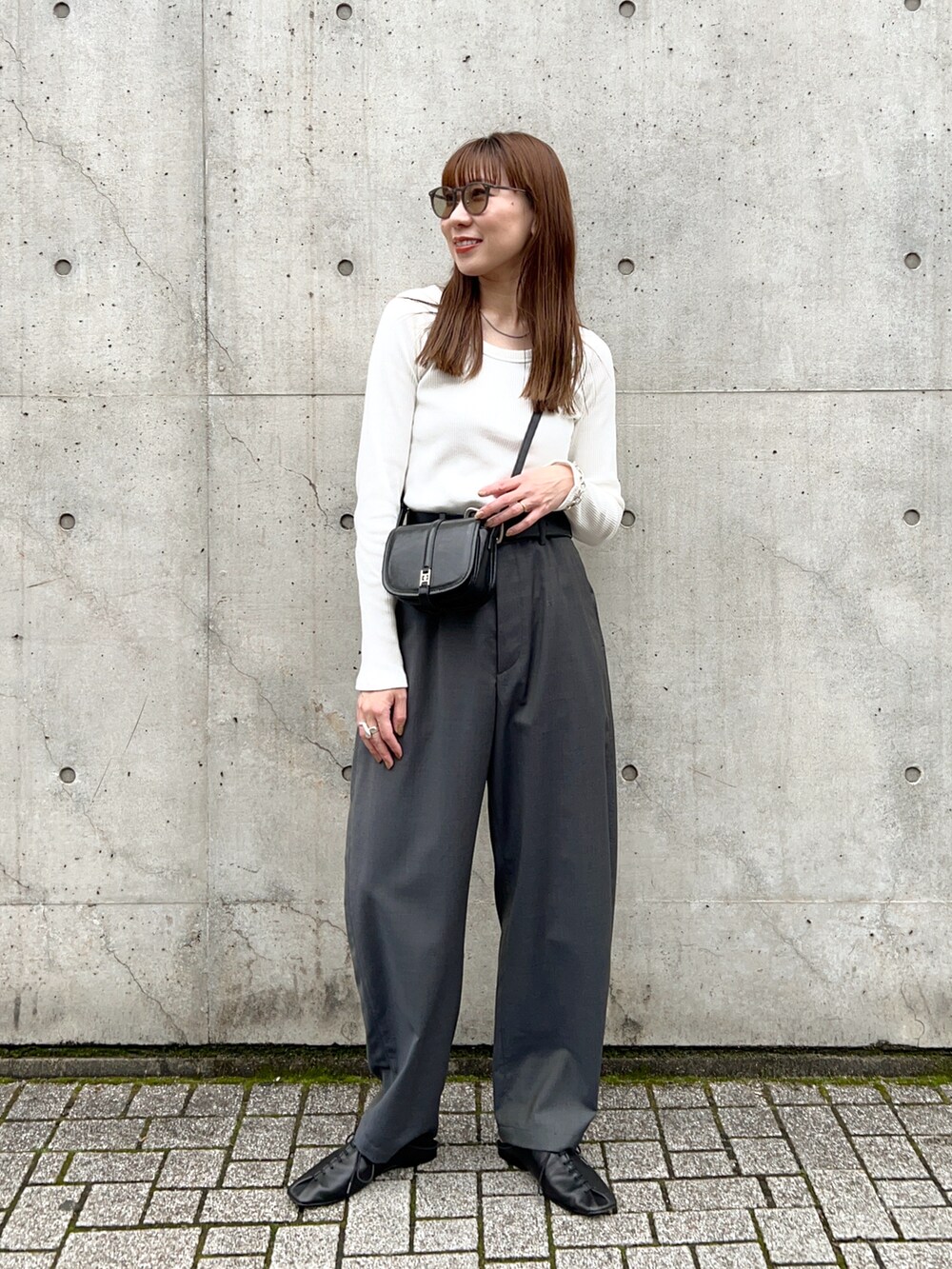 ホワイト系のTシャツ/カットソー、グレー系のその他パンツ、ブラック系のスリッポンを着用したレディースの春コーディネートの3枚目の写真