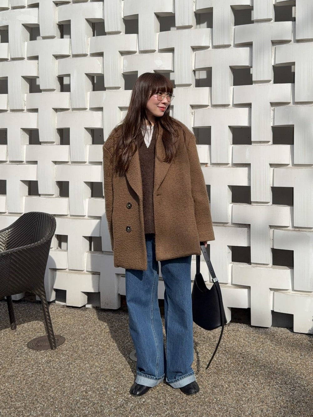 ブラウン系のその他アウター、ブルー系のデニムパンツ、ブラウン系のニット/セーターを着用したレディースの冬コーディネートの2枚目の写真