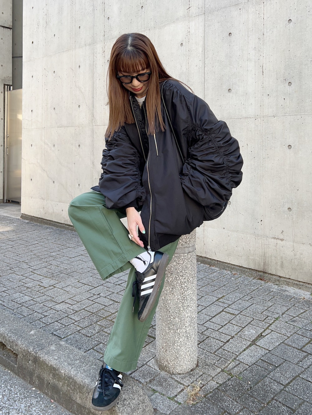 ブラック系のMA-1、ブラック系のハンドバッグ、ホワイト系のTシャツ/カットソーを着用したレディースの冬コーディネートの3枚目の写真