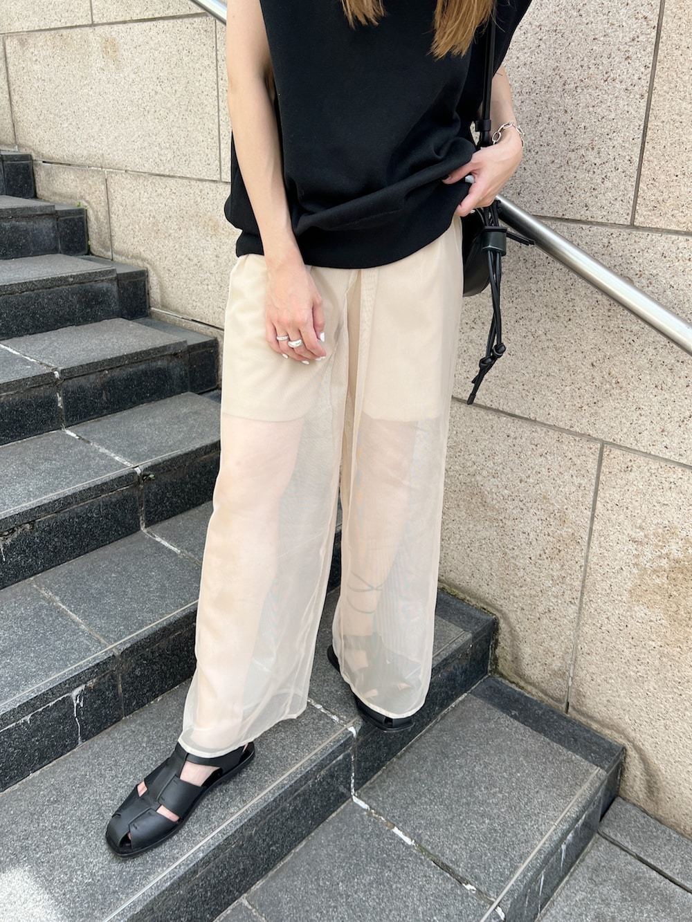 ブラック系のニット/セーター、ベージュ系のその他パンツ、ブラック系のサンダルを着用したレディースの夏コーディネートの5枚目の写真