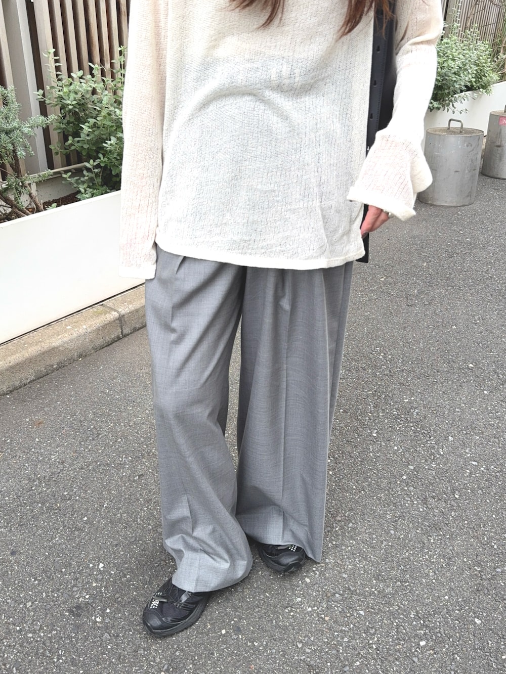 グレー系のその他パンツ、ホワイト系のトップス、ブラック系のバッグを着用したレディースの秋コーディネートの4枚目の写真