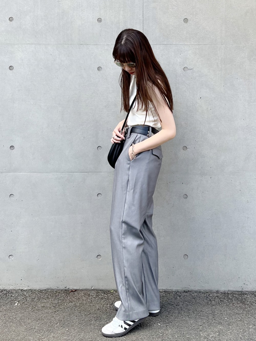 ホワイト系のタンクトップ、グレー系のスラックス、ホワイト系のスニーカーを着用したレディースの夏コーディネートの2枚目の写真