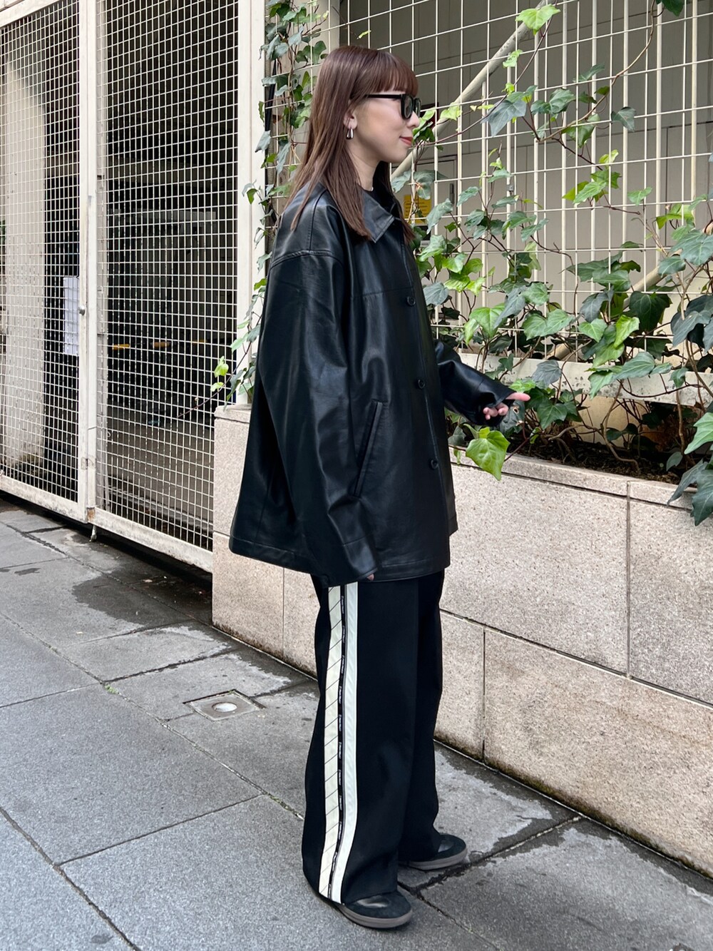 ブラック系のその他アウター、ブラック系のニット/セーター、ホワイト系のTシャツ/カットソーを着用したレディースの冬コーディネートの2枚目の写真