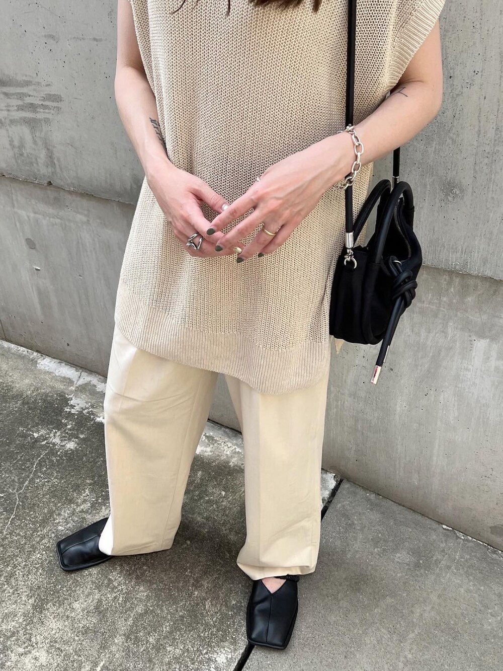 ホワイト系のパンツ、ブラック系のスリッポン、ベージュ系のトップスを着用したレディースの夏コーディネートの5枚目の写真