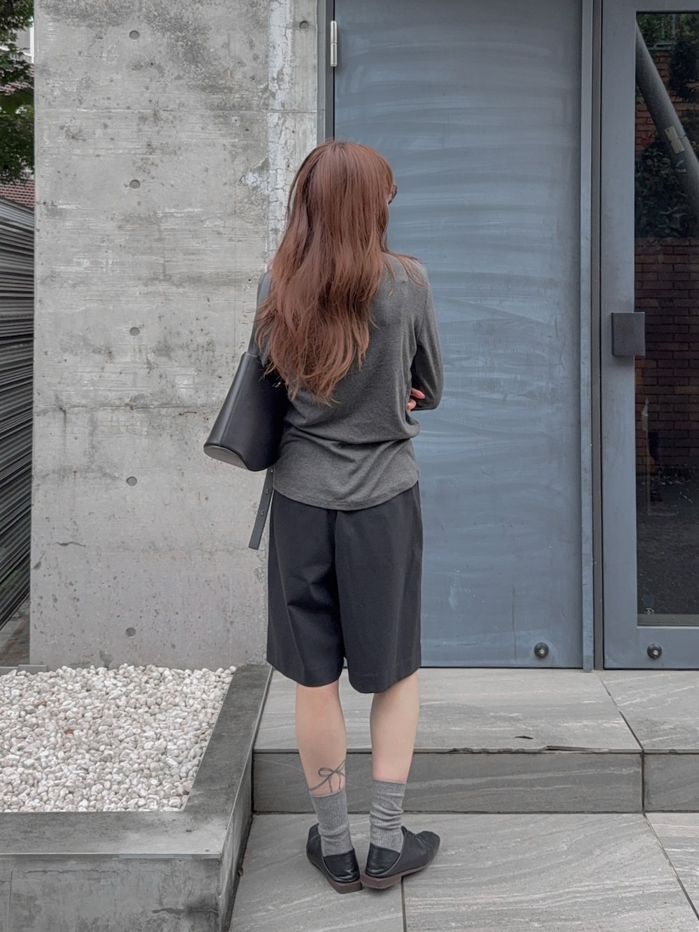 ブラック系のその他パンツ、グレー系のTシャツ/カットソー、ブラック系のバッグを着用したレディースの秋コーディネートの2枚目の写真